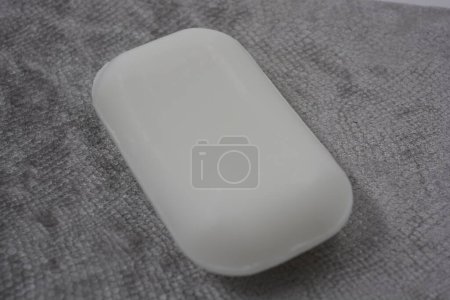 Téléchargez les photos : Magnifique, élégant, barre blanche de savon sans logo et nom placé sur un fond gris, velours écailleux. - en image libre de droit