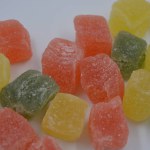 Beautiful, small pieces of gummy confections. Delicious, natural, fruity marmalade in green, yellow, red colors arranged on a white background.