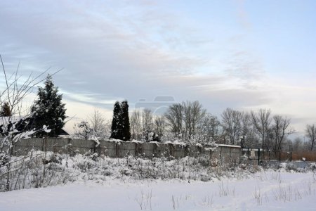Una ciudad de invierno y noche con personas, bancos, casas, edificios, nieve blanca, árboles desnudos, linternas se encuentran a lo largo del río Dnipro. Secciones muy inusuales del terraplén de invierno del río Dnipro en la ciudad nocturna de Dnepropetrovsk / Dnipro, Ucrania. 