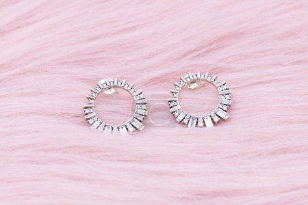 Téléchargez les photos : Earrings jewelry, Close up of a pair of luxury earrings on a pink background. Elegant earrings for women. - en image libre de droit