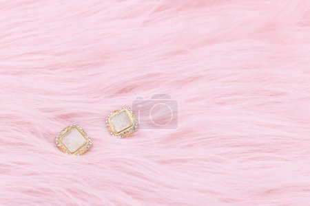 Téléchargez les photos : Earrings jewelry, Close up of a pair of luxury earrings on a pink background. Elegant earrings with copy space. - en image libre de droit