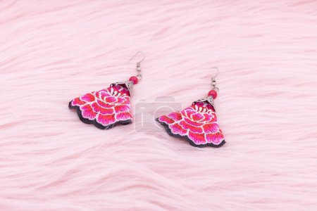 Téléchargez les photos : Chinese earrings, Close up of a pair of chinese style earrings on a pink background. Antique earrings for women. - en image libre de droit