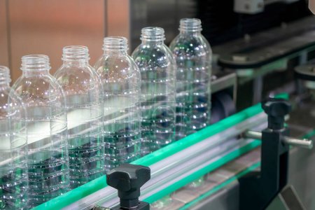 Photo for Close up scene of the empty drinking water bottles  on the conveyor belt for filling process. The hi-technology of drinking water manufacturing process. - Royalty Free Image