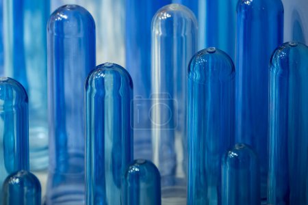 Téléchargez les photos : The close up scene of group of preform shape of PET bottle products. The raw material for plastic bottle manufacturing process. - en image libre de droit