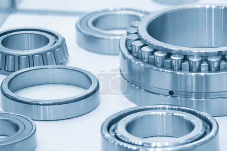 Photo for The cylindrical rolling bearing parts in light blue scene. The heavy mechanical part manufacturing concept. - Royalty Free Image