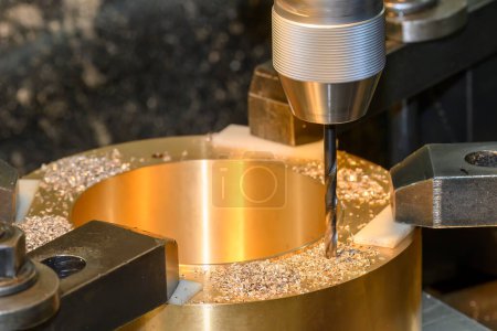Foto de The drilling process on NC milling machine with brass material. The metal working concept on the milling machine. - Imagen libre de derechos