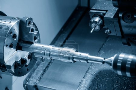 Die CNC-Drehmaschine Schlitz Schneiden der Metallwellen Teile durch Fräsen Spindel. Die hochtechnologische Metallbearbeitung mit CNC-Drehmaschine.