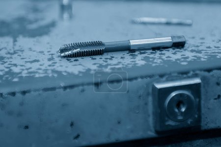 Photo for Close up of the  used machine tapping tool in light blue scene. The thread cutting concept on machining center. - Royalty Free Image