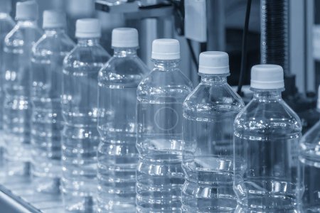 Foto de The hi-technology of drinking water manufacturing process. The  empty drinking water bottles  on the conveyor belt for filling process. - Imagen libre de derechos