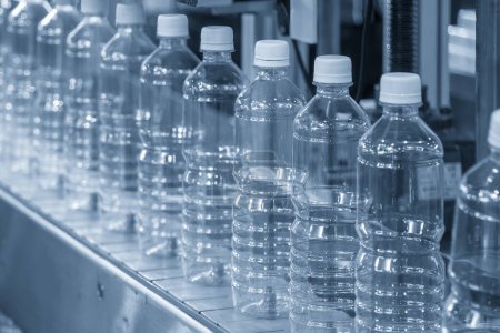 Foto de The hi-technology of drinking water manufacturing process. The  empty drinking water bottles  on the conveyor belt for filling process. - Imagen libre de derechos
