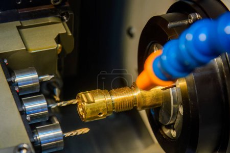 Photo for The  multi tasking CNC lathe machine swiss type drilling the brass fitting parts. The hi-technology metal working processing by CNC turning machine . - Royalty Free Image