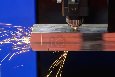 Nahaufnahme Szene der Faser-Laser-Schneidemaschine schnitt das quadratische Edelstahlrohr und funkelndes Licht. Der hochtechnologische Prozess der Blechherstellung mittels Laserschneidmaschine. 