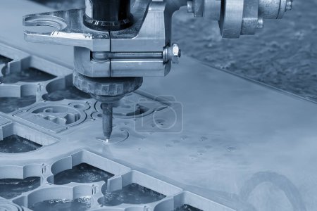 Die abrasive Wasserstrahlschneidemaschine schneidet die Metallplatte in der hellblauen Szene. Die hochtechnologische Blechbearbeitung mit CNC-Maschine.