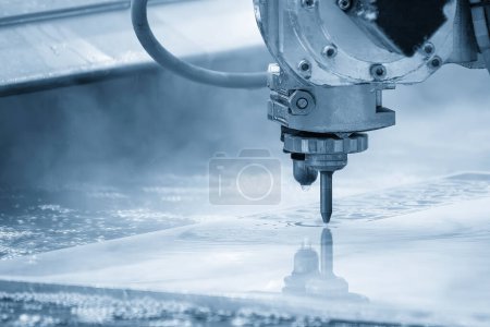 La machine de découpe jet d'eau abrasif multi-axes coupant la plaque métallique dans la scène bleu clair. La tôle de haute technologie travaillant avec une machine CNC.