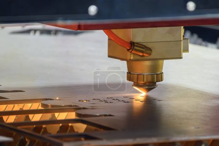 Téléchargez les photos : La machine de découpe laser à fibre a coupé la plaque métallique avec la lumière scintillante. Le procédé de fabrication de tôles de haute technologie par machine de découpe laser. - en image libre de droit