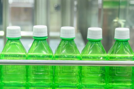 Foto de Las botellas vacías verdes en la cinta transportadora para el proceso de llenado. La alta tecnología del proceso de fabricación de agua potable. - Imagen libre de derechos