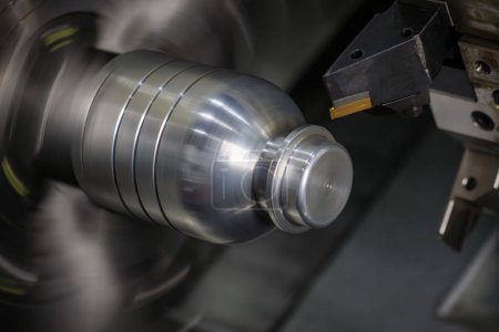 La máquina de torno CNC que forma el corte de las piezas del eje de metal. El procesamiento de mecanizado de metales de alta tecnología por máquina de torneado CNC .