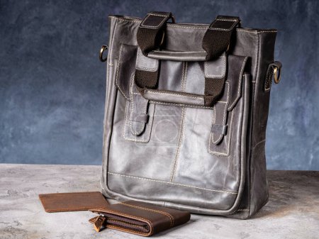 Foto de Folding EDC knife and wallet with cardholder near a vintage leather casual bag - Imagen libre de derechos