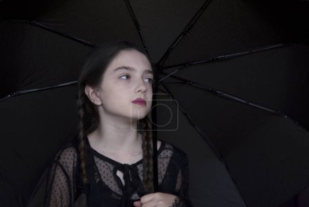 Photo for Halloween: Girl with a pumpkin and a black umbrella in her hands - Royalty Free Image
