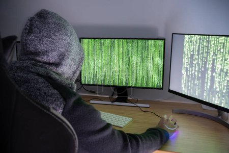 Foto de The Hooded Hacker: Planning the Next crime. - Imagen libre de derechos