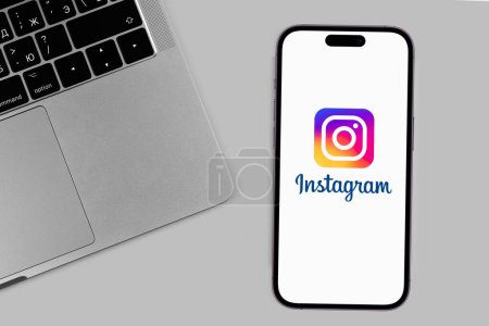 Photo for Instagram logo mobile app on the screen smartphone iPhone with Macbook keyboard. Instagram is a photo-sharing app for smartphones. Batumi, Georgia - December 11, 2022 - Royalty Free Image