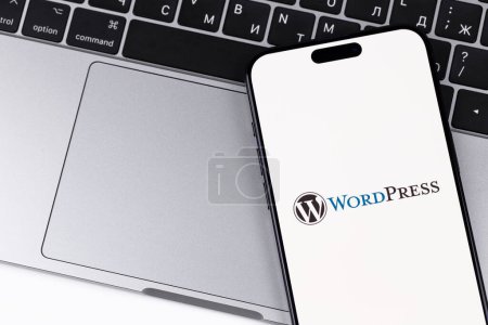 Photo for WordPress logo mobile app on a screen smartphone iPhone with Macbook background. WordPress - open source site content management system. Batumi, Georgia - October 28, 2023 - Royalty Free Image