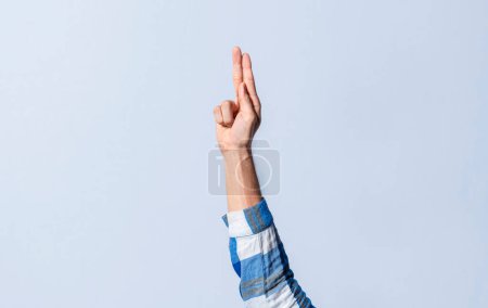 Photo for Hand gesturing the letter U in sign language on an isolated background. Man's hand gesturing the letter U of the alphabet isolated. Letter U of the alphabet in sign language - Royalty Free Image