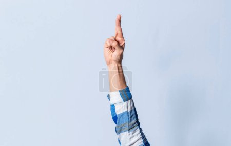Photo for Hand gesturing the letter R in sign language on an isolated background. Man's hand gesturing the letter R of the alphabet isolated. Letter R of the alphabet in sign language - Royalty Free Image