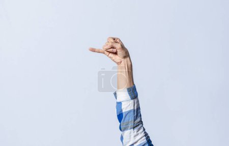 Photo for Hand gesturing the letter J in sign language on an isolated background. Man's hand gesturing the letter J of the alphabet isolated. Letters of the alphabet in sign language - Royalty Free Image