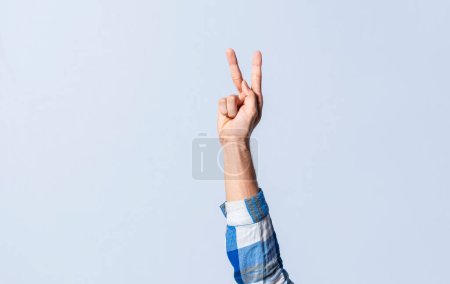 Photo for Hand gesturing the letter K in sign language on an isolated background. Man's hand gesturing the letter K of the alphabet isolated. Letters of the alphabet in sign language - Royalty Free Image