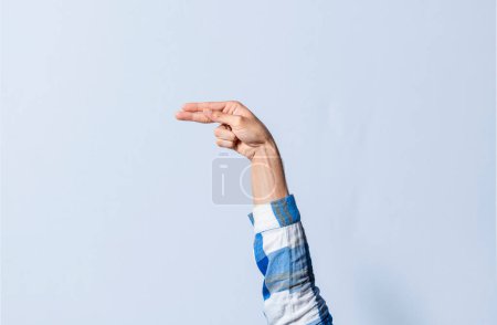Photo for Hand gesturing the letter H in sign language on an isolated background. Man's hand gesturing the letter H of the alphabet isolated. Letters of the alphabet in sign language - Royalty Free Image