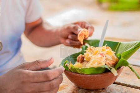 Primer plano de la persona comiendo vigorón en la mesa. Persona local comiendo un vigorn tradicional. El vigorón comida típica de Granada, Concepto de comida típica de Nicaragua