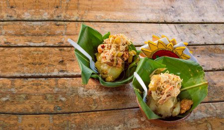 Vigorón tradicional en hojas de plátano servido sobre una mesa de madera. Dos vigorones nicaragüenses servidos sobre madera. El vigorón comida típica de Granada, Nicaragua