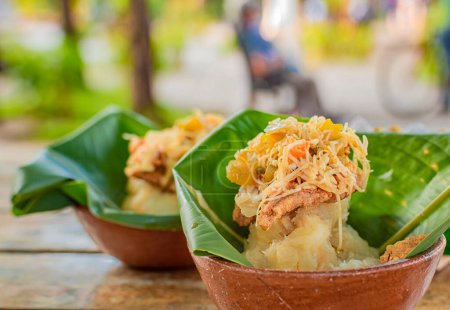 Großaufnahme von zwei Vitalones, die auf einem Holztisch serviert werden. Die kräftige typische Küche von Granada, Nicaragua. Traditioneller Vigoron in Bananenblättern, serviert auf einem Holztisch. Nicaragua-Ernährungskonzept