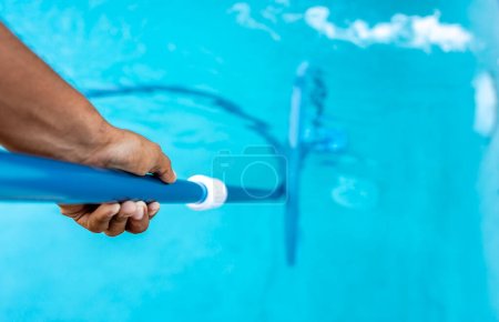 People cleaning swimming pool with suction hose. Close-up of man cleaning a swimming pool with a vacuum hose, Pool maintenance and cleaning with vacuum hose