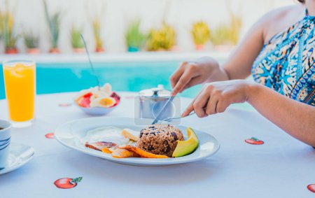 Téléchargez les photos : Petit déjeuner près de la piscine. mains de fille avec un petit déjeuner près de la piscine - en image libre de droit