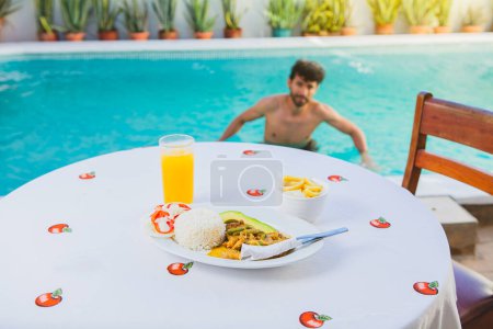 Téléchargez les photos : Petit déjeuner traditionnel près de la piscine, Petit déjeuner traditionnel servi au bord de la piscine - en image libre de droit