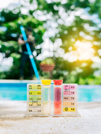 Photo for Pool water PH tester kit on the edge of the swimming pool. Tester kit to measure chlorine and ph in swimming pools - Royalty Free Image