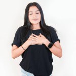 Thankful people with hands on chest. Grateful teenage girl smiling with hands on chest isolated. Positive latin girl with hands on chest