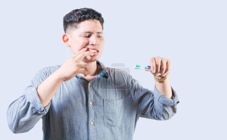 Hombre sufriendo de dolor de encías sosteniendo el cepillo de dientes. Gente sosteniendo cepillo de dientes con problemas de encías. Persona con gingivitis sosteniendo cepillo de dientes aislado