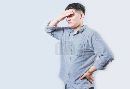Tired man holding his head isolated. Worried young man holding his forehead isolated
