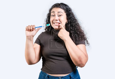 Mädchen mit Zahnfleischschmerzen halten Zahnbürste in der Hand. Junge Frau mit Zahnfleischentzündung hält Zahnbürste isoliert. Menschen mit Zahnbürste mit Zahnfleischproblem