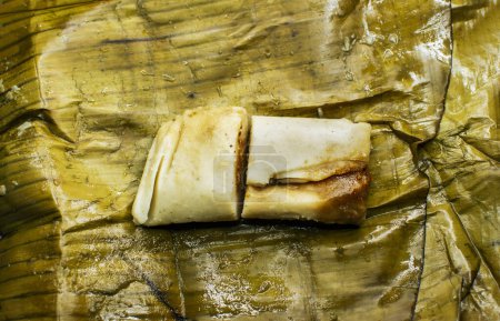 Traditionelle Tamale in Bananenblättern serviert. Draufsicht auf eine traditionelle Tamale auf einem Bananenblatt. Nicaraguanische Pisque Tamale auf Bananenblatt. Tamalpisque traditionelle zentralamerikanische Küche