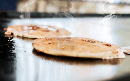 Photo for Close up of traditional handmade pupusas on grill, Traditional Nicaraguan Pupusas with melted cheese on grill. Traditional grilled cheese pupusas - Royalty Free Image