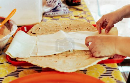 Préparation du Quesillo nicaraguayen traditionnel. Une personne qui fait du délicieux fromage nicaraguayen. Fromage traditionnel à l'oignon mariné, Mains préparant le Quesillo nicaraguayen traditionnel