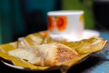 Tamale farcie servie sur table en bois, tamale farcie sur feuille de banane servie sur table en bois, nourriture typique du nicaragua