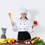 Woman chef holding a ladle on a table with vegetables, A smiling woman chef holding a ladle and vegetables, portrait of a woman chef holding a ladle on isolated background