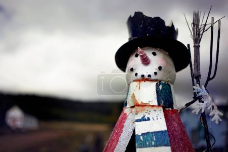 Photo for Wooden Snowman decoration with mountains in the background on a cloudy day. - Royalty Free Image