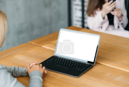 Photo for Online conference. Computer mockup. Office work. Unrecognizable woman sitting desk looking laptop blank screen in light room interior. - Royalty Free Image