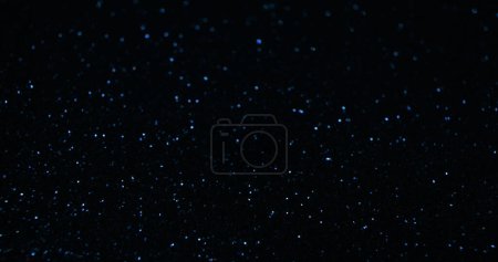 Foto de Antecedentes brillantes. Textura de brillo Bokeh. Estrellas del cielo nocturno. Reflejo de luz de color azul desenfocado en negro oscuro abstracto espacio libre fondo de pantalla. - Imagen libre de derechos